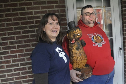 Anthony Skariot and his wife, Deana Carpenter, the founders of The Outer Circle, pose with a wooden groundhog statue at their Castle Shannon home Wednesday. The club celebrates Groundhog Day all year round.