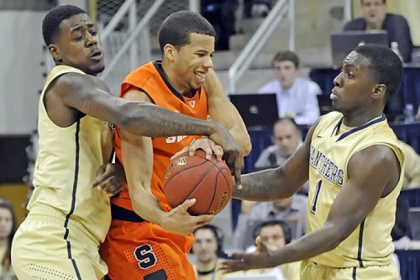 Pitt's Dante Taylor and Tray Woodall reach to steal the ball from Syracuse's Michael Gbinije in the second half at the Petersen Events Center this afternoon.