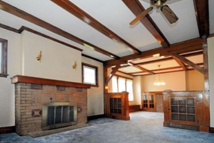 The living room has wall-to-wall carpeting covering hardwood floors and a gas fireplace with brick surround.