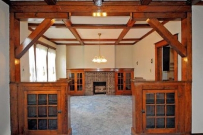 This view of the dining room from the living room displays the rooms' built-in cabinets and ceiling beams.