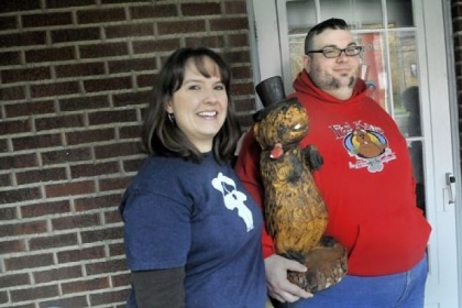 Deana Carpenter, left, and husband, Anthony Skariot, are the founders of the Outer Circle, a club that celebrates Groundhog Day all year round. Above, they pose with a wooden groundhog statue Wednesday at their Castle Shannon home.