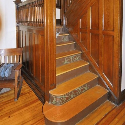 Removing a dropped ceiling revealed the wooden archway above the front staircase. Heather McElwee stenciled dragonflies on the risers of the stairs.