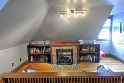 In the third floor master suite of the Morningside Four-square, Chris Clarke forged a fireplace screen out of iron and built the bookcases. The handmade Amish settle, in the foreground, was a gift.