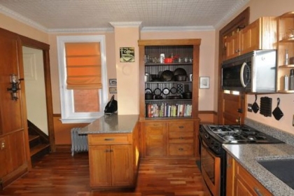 The dining room shows the contrast between the couple's blond mid-century modern furniture and original Craftsman-style fireplace with copper hood. Heather McElwee's father made the walnut clock on the mantel.