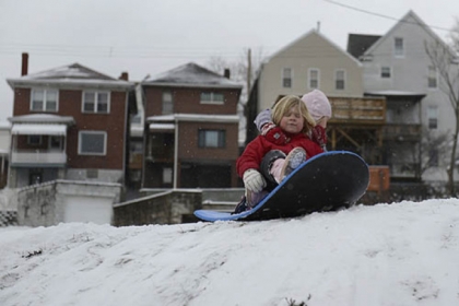 Sisters Ana Jean, 5, (right) and Magdalen McDermott, 4, prepare for a sledding run in their yard in Greenfield on Sunday.