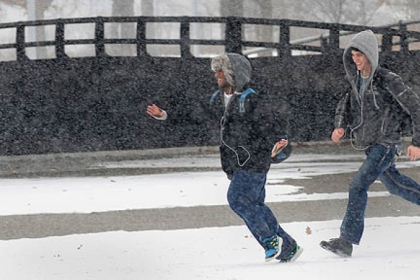 Patrick Terry and Eli McCary walk through the snow at Point State Park during today's snowfall