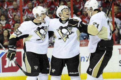 Penguins left winger Chris Kunitz, center, celebrates his goal in the second period with teammates Sidney Crosby, left, and Evgeni Malkin in Washington Sunday. Kunitz had a hat trick with goals in the second and third periods.