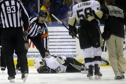 Penguins center Sidney Crosby lies on the ice after he was hit in the face in the second period against the Islanders.