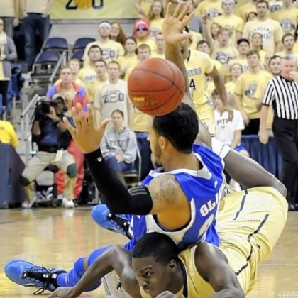 Pitt''s Tray Woodall lands underneath Brian Oliver in the first half at the Petersen Events Center Monday night.