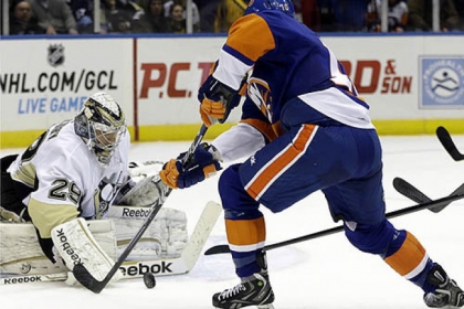 Penguins goalie Marc-Andre Fleury makes a save as Islanders center Keith Aucoin skates in front of the crease in the second period.