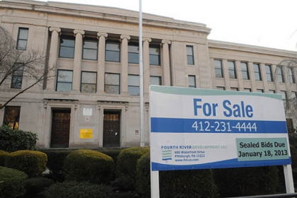 A "For Sale" sign stands in front of the former Pittsburgh Schenley High School.