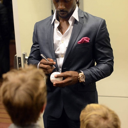 The Pirates' Andrew McCutchen signs a ball for a fan.