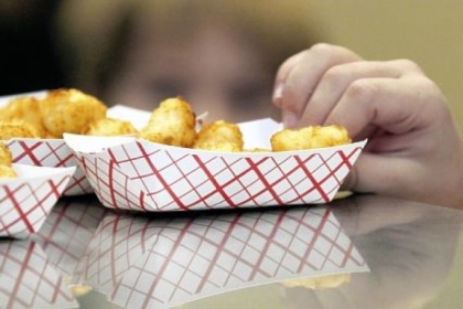 Little fingers reach for tater tots during lunch at an elementary School in Brandon, Miss.