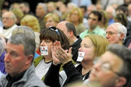 Lisa DeSantis, left, of New Castle and Maggie Henry of Bessemer cover their mouths with Ban Fracking Now stickers during a hearing about the county's deal with Consol Energy to extract natural gas from land at Pittsburgh International Airport.