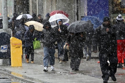 Snow was falling on Friday as morning rush hour pedestrians made their way to work along Delancey Street in New York City.