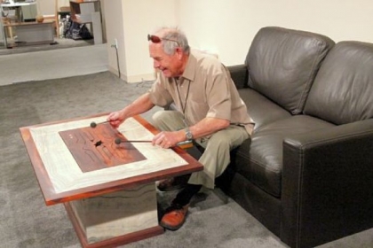 Michael Thiele of the Hardwood Music company plays this acoustic coffee table constructed of Guatemalan rose wood.