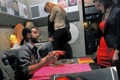 James Gyre, left, talks to customers about his prints at CAVO in the Strip.