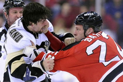 The New Jersey Devils' Krystofer Barch, right, fights with the Penguins' Deryk Engelland during the first period of this afternoon's NHL hockey game in Newark.