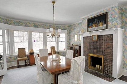 The dining room's architectural features include crown molding. The fireplace, one of many in the home, is decorative.