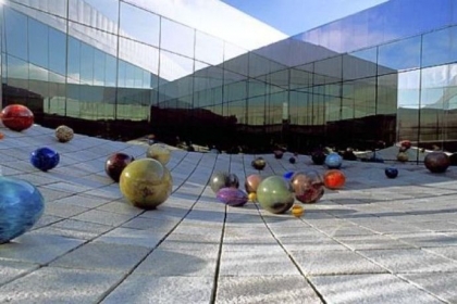 Richard Rhodes' untitled "stone wave" sculpture at Tacoma Art Museum is decorated with Ma Chihuly's Floats (in honor od Dale Chihuly's mother) during the summer months.