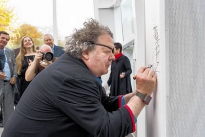 Dale Chihuly signs his name at the center's opening.
