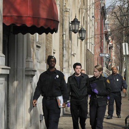 A team from the Medical Examiner's office arrive at the YMCA, along West North Avenue on the Northside.