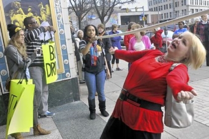 Sheila May-Stein, a substitute teacher in Pittsburgh Public Schools, does the limbo to get into the Kelly Strayhorn Theater on Sunday in East Liberty for a rally to protest cuts in education by the Corbett administration. The bar was set lower depending on the cuts to specific schools. Holding the bar is Gabriella Jones-Casey of One Pittsburgh.