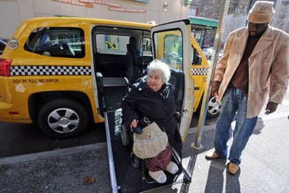 Lucy Spruill of Squirrel Hill rolls down the ramp from her taxi ride to Market Square with driver Eddie Green Monday.