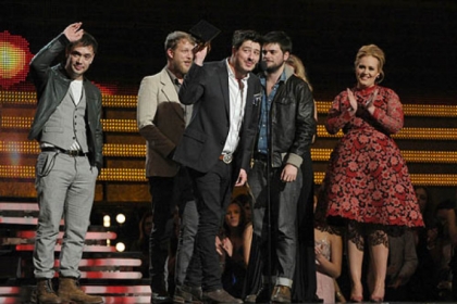 Mumford & Sons, from left, Ben Lovett, Ted Dwayne, Marcus Mumford and Country Winston Marshall accept the award for album of the year for "Babel" at the 55th annual Grammy Awards on Sunday in Los Angeles. Presenter Adele, right, claps.