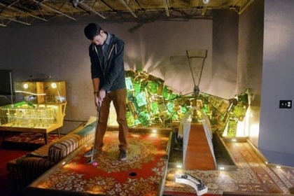 Nick Barletta putts in a mini-golf game at PLAY Parlour.