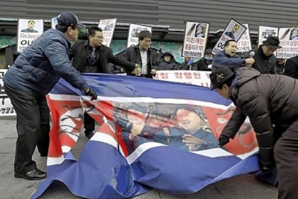 South Korean protesters slit up a North Korean flag with defaced portraits of North Korean leader Kim Jong Un and his wife, Ri Sol Ju, during an anti-North Korea rally Tuesday in Seoul, South Korea, following a nuclear test conducted by North Korea. The signs read "Out, Kim Jong Un."
