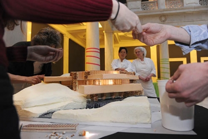 Seung Mee Choi, assistant pastry chef, left, and Alice Leich, executive pastry chef, both of Parkhurst Dining at the Carnegie Museums, watch as the Loysen   Kreuthmeier Architects/Prantl's Bakery team builds "Fallingwater" an edible cake.