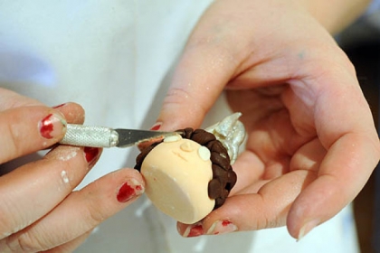 Megan Hart, head cake designer at Dozen Bakeshop, creates Queen Sarah Saturday, a character from the Land of the Maple Leaf, for a Mr. Rogers' Neighborhood themed cake.