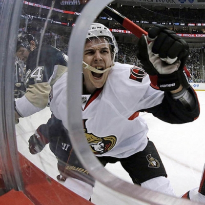 Ottawa Senators defenseman Erik Karlsson, center, grimaces as he hits the boards after colliding with Penguins left wing Matt Cooke Thursday night.