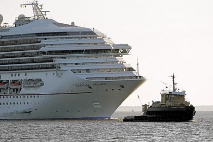 The cruise ship Carnival Triumph is towed into Mobile Bay near Dauphin Island, Ala., on Thursday. The ship with more than 4,200 passengers and crew members has been idled for nearly a week in the Gulf of Mexico following an engine room fire.