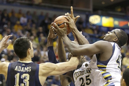 Pitt's Steven Adams fights for a rebound with Marquette's Steve Taylor Jr. and Chris Otule, right, during the first half of today's game in Milwaukee.