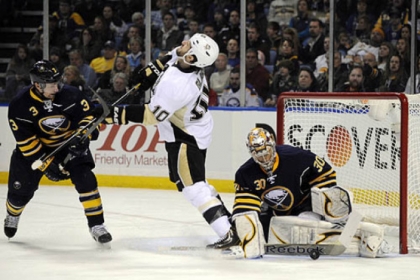 Buffalo Sabres defenseman Jordan Leopold, left, gets his stick up in the face of Penguins left winger Tanner Glass as Buffalo goaltender Ryan Miller eyes the puck Sunday.