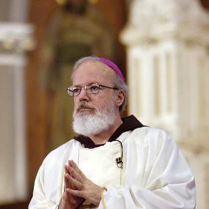 Sean O'Malley folds his hands in prayer at the Cathedral of the Holy Cross during his installment as the new Roman Catholic Archbishop of the Boston Archdiocese July 30, 2003 in Boston.