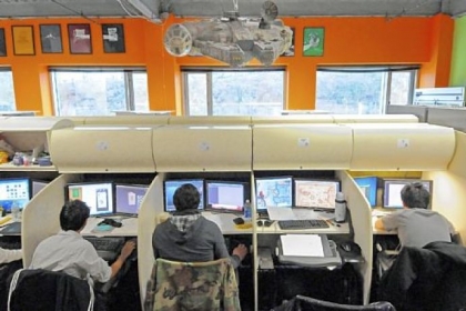 Students work on projects beneath a model of the Millennium Falcon from the "Star Wars" movies.