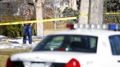 Michael Ignace, a neighbor, takes in the scene where four people, including the assailant, were found dead Saturday morning after the gunman held police at bay for several hours in Aurora, Colo.