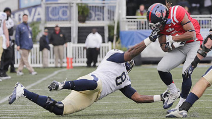 Pitt linebacker Todd Thomas grabs the face mask of Mississippi running back Jeff Scott in the first quarter of the BBVA Compass Bowl.