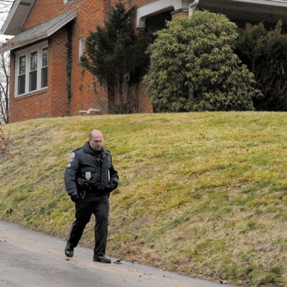 An officer walks along the driveway outside the site of a fatal stabbing on Gibsonia Road.