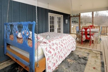The enclosed rear porch with swinging bed is off the first-floor master bedroom.