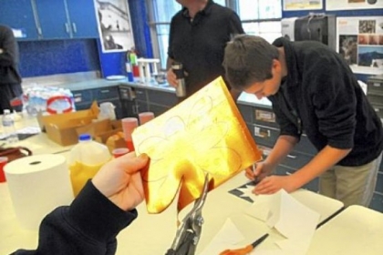 A sheet of copper is fashioned into a flower petal for a sculpture that will be placed at Jefferson Middle School to remember student Leah Blum, who died in 2009. Students at the school in Mt. Lebanon made the petals Monday under the guidance of Jan Loney, who is serving as artist in residence at the school.