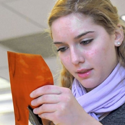 Student Emilia Riccinti fashions a flower petal from a copper sheet.