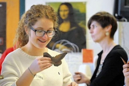Student Alana Rascoe admires the butterfly she has created from a copper sheet.