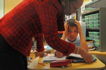Second-grader Aundra Payne looks up as superintendent Linda Lane asks him about what he is reading at Pittsburgh Morrow PreK-6 in Brighton Heights.