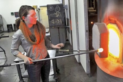 Adrienne Remo, a senior at Pine-Richland High School, pulls glass from the furnace for a project last Thursday at the Pittsburgh Glass Center.