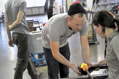 Jason Forck, who teaches an intermediate glass blowing class at the Pittsburgh Glass Center, works with Adrienne Remo.