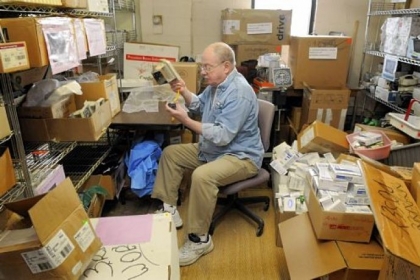 Jim Carr of Shaler, a retired phone company technician, checks and fixes blood pressure monitors in a back room of Global Links in Garfield. Mr. Carr volunteers at Global Links four to six hours a week.